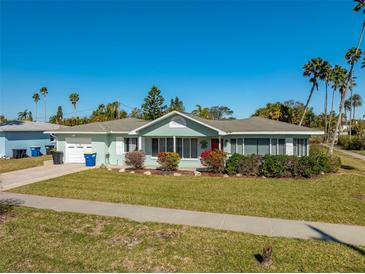 Charming single-story home with a well-manicured lawn and a red front door at 66 Kipling Plz, Clearwater Beach, FL 33767