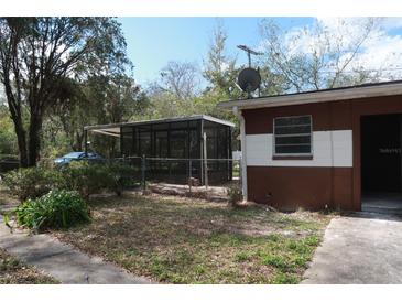 Backyard view of the house with screened in porch at 13924 Morgan St, Dade City, FL 33525