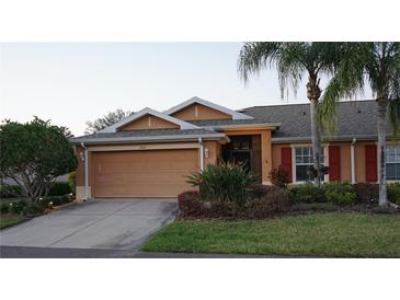 Charming single-story home with a two-car garage, landscaped yard, and beautiful tropical plants at 2025 Grantham Greens Dr # 52, Sun City Center, FL 33573