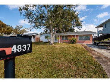 Charming red brick home featuring a spacious yard and mature tree at 4837 97Th N Way, St Petersburg, FL 33708