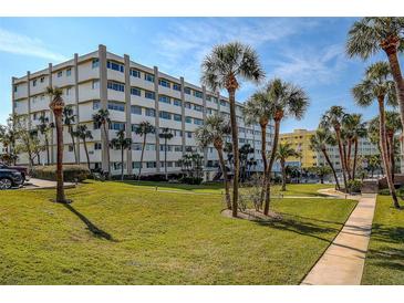 A well maintained building exterior featuring lush landscaping and an inviting entrance on a sunny day at 100 Bluff View Dr # 514A, Belleair Bluffs, FL 33770