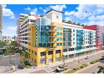 Multi-story condo building featuring colorful architecture, street-level retail, and balconies, set against a bright blue sky at 1208 E Kennedy Blvd # 1017, Tampa, FL 33602