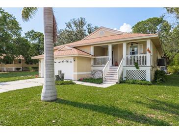 Inviting home with front porch, lush lawn, and attached garage at 1312 Gulf Rd, Tarpon Springs, FL 34689