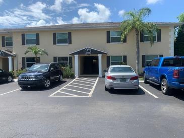 Two-story apartment building with parking, mature trees, and visible unit numbers on the exterior facade at 13125 N Wilcox Rd # 7105, Largo, FL 33774