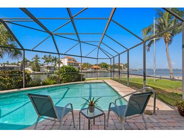 Relaxing screened-in pool area, with lounge chairs, and overlooking a scenic waterfront view at 4464 46Th S Ave, St Petersburg, FL 33711