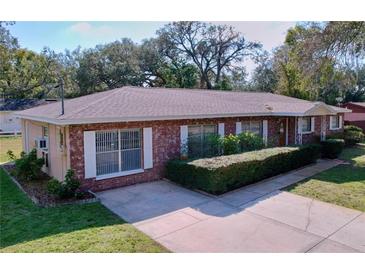 Charming brick home with a well-manicured lawn and a spacious driveway at 5009 E Kirby St, Tampa, FL 33617