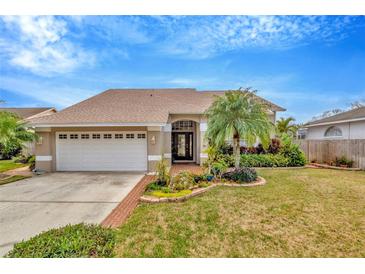 Charming single Gathering home with a manicured lawn, lovely landscaping and a two car garage at 6208 Forrestal Dr, Tampa, FL 33625