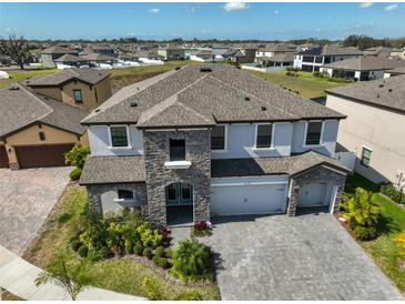 Stunning two-story home with stone accents, well-manicured landscaping, and a paved driveway at 12779 Fisherville Way, Riverview, FL 33579