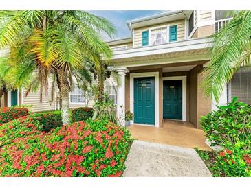 Inviting condo front entrance with lush landscaping and bright, teal colored doors at 8926 Manor Loop # 207, Lakewood Ranch, FL 34202