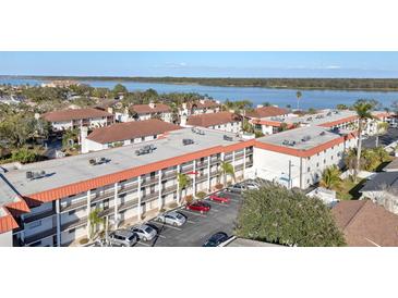 Condominium exterior featuring a terracotta roof, palm trees, and parking at 10540 77Th Ter # 209, Seminole, FL 33772