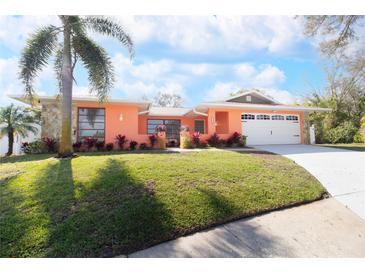 Charming single-story home with vibrant exterior, well-manicured lawn, and large driveway at 112 Forest Cir, Safety Harbor, FL 34695