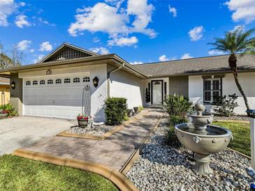 Charming home exterior featuring a well-maintained lawn, beautiful fountain and a two-car garage at 15109 Winterwind Dr, Tampa, FL 33624