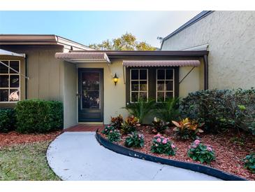 Charming front entrance with landscaped garden and covered doorway at 2101 Sunset Point Rd # 1003, Clearwater, FL 33765