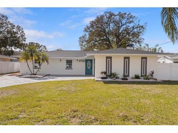 Charming single-story home with a brick facade, manicured lawn, and a modern design at 4908 Stolls Ave, Tampa, FL 33615