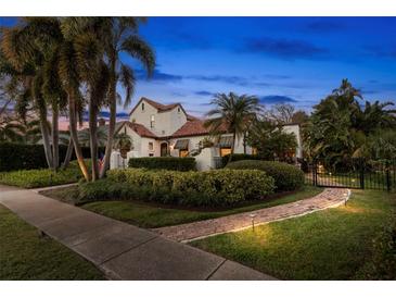 Charming home featuring lush landscaping, a red tile roof, and a welcoming garden path at 719 21St N Ave, St Petersburg, FL 33704