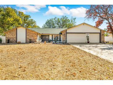 Charming single-story brick home with a well-maintained yard, two-car garage, and inviting front entrance at 7948 Floral Dr, Weeki Wachee, FL 34607