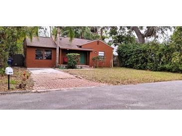 Charming bungalow with mature trees and a brick driveway at 8006 N Temple Pl, Tampa, FL 33617