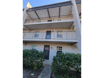 Condo exterior featuring multiple stories with balconies and front door access at 8765 Bardmoor Blvd # 107, Seminole, FL 33777