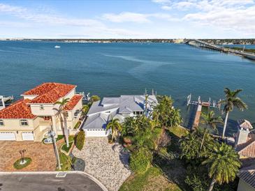 Waterfront home boasts lush tropical landscaping, a private dock, and stunning views of the bay and bridge at 1201 Bay Dr, Belleair Beach, FL 33786