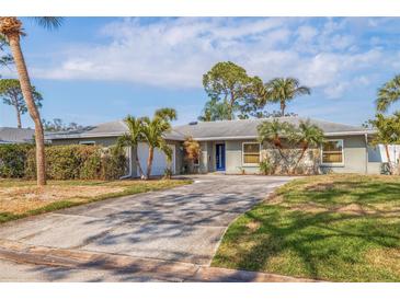 Charming single-story home featuring a well-maintained front yard with a paved driveway and attractive landscaping at 2031 Tanglewood Ne Way, St Petersburg, FL 33702