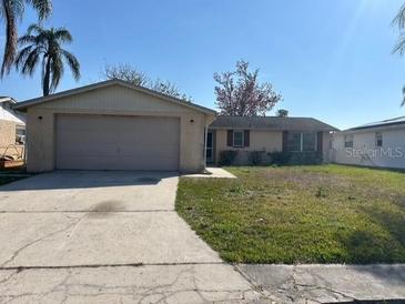 Charming single-story home featuring an attached two-car garage and well-maintained front lawn at 3320 Jackson Dr, Holiday, FL 34691