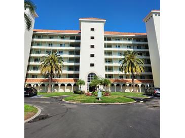 Beautiful condo building with classic design, lush landscaping, and roundabout entrance at 4801 Osprey S Dr # 209, St Petersburg, FL 33711