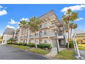 Well-maintained condo building with lush landscaping and palm trees under a bright blue sky at 716 Cordova Grn, Seminole, FL 33777