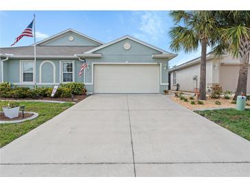 Charming single-story home with a well-maintained lawn, two-car garage, and American flag at 7497 W Lenox Cir, Punta Gorda, FL 33950