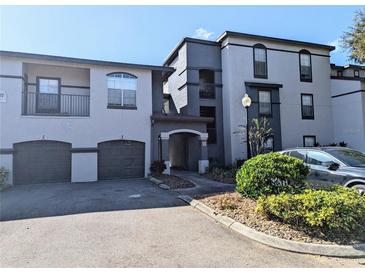 Condo exterior with two-tone paint, two garage doors, and an arched entryway at 8517 Sea Harbour Ln # 103, Temple Terrace, FL 33637