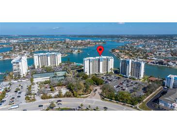 Beautiful aerial view of condo complex on the water featuring a pool and ample parking at 9425 Blind Pass Rd # 506, St Pete Beach, FL 33706