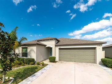 Charming single-story home with a well-maintained lawn, two-car garage and inviting entrance at 9636 Channing Hill Dr, Ruskin, FL 33573