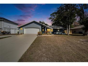 Charming single-story home with a well-manicured lawn and an attached two-car garage at 11283 Portsmouth St, Spring Hill, FL 34609