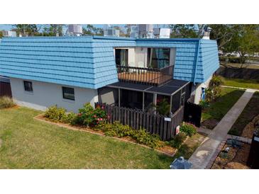 Charming townhome boasts blue roof, screened lanai, and a private balcony overlooking lush landscaping at 14511 Catalina Cir # 14511, Seminole, FL 33776