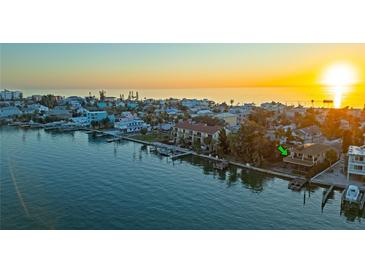 Waterfront home featuring a boat dock and stunning sunset views over the water at 148 93Rd Ave, Treasure Island, FL 33706