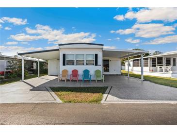 Charming single-story home with a covered carport and cozy outdoor seating area at 37150 Sandra Ave, Zephyrhills, FL 33542