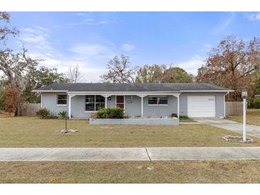 Charming single-story home with a well-maintained lawn, covered porch, and attached garage, offering curb appeal at 4553 Kirkland Ave, Spring Hill, FL 34606