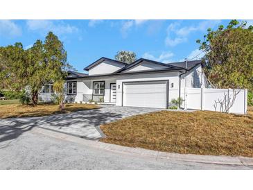 Beautiful exterior showcasing the home's modern architecture and the brick driveway leading to the two-car garage at 5891 64Th N St, St Petersburg, FL 33713