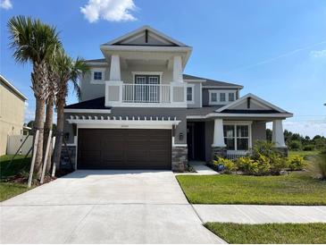 Beautiful two-story home with an attached two-car garage, second story balcony and well-manicured front lawn at 33947 Astoria Cir, Wesley Chapel, FL 33545