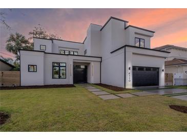 Stunning modern home boasting clean lines, a two-car garage, and lush green landscaping at 4110 W Swann Ave, Tampa, FL 33609