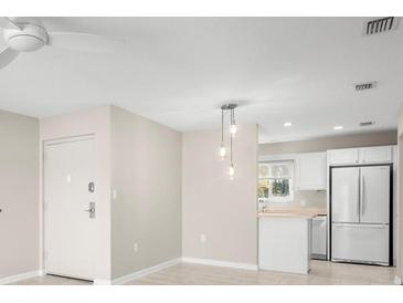 Open-concept living space with pendant lighting and view of kitchen featuring white appliances at 4215 E Bay Dr # 1601D, Clearwater, FL 33764