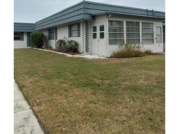 Charming single-story home with a well-maintained lawn and enclosed porch at 1811 Bedford Ln # 162, Sun City Center, FL 33573