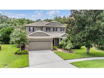 Charming two-story home with a well-manicured lawn and attached two-car garage at 19308 Sunset Bay Dr, Land O Lakes, FL 34638