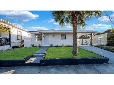 Charming single-story home with a well-manicured front yard and a lovely palm tree at 2540 W Pine St, Tampa, FL 33607