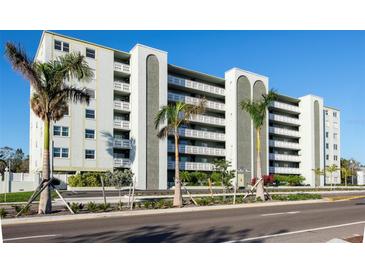 Multi-story building featuring private balconies, palm trees, and well-maintained landscaping at 7321 Central Ave # 402, St Petersburg, FL 33710