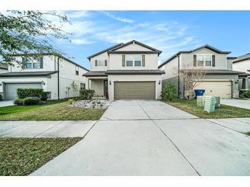 Charming two-story home featuring a well-maintained lawn and a two-car garage at 7673 Yale Harbor Dr, Wesley Chapel, FL 33545