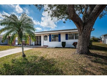 Charming single-story home with a well-maintained lawn, palm tree, and white exterior with blue shutters at 10022 Lily N St # N, Pinellas Park, FL 33782