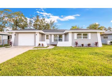 Charming single-story home featuring a well-manicured lawn and a freshly painted gray exterior at 1811 Forest Dr, Oldsmar, FL 34677