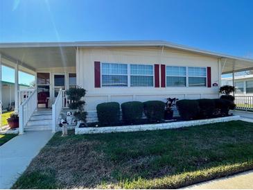 Charming single-story home featuring a covered porch, well-maintained lawn, and neat landscaping at 205 Seagull N Dr, Tarpon Springs, FL 34689