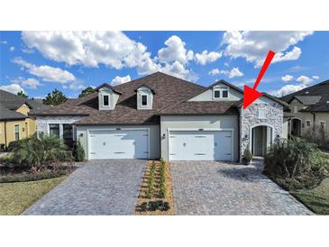 Charming home featuring a stone entryway, manicured landscaping, and a two-car garage at 4375 Barletta Ct, Wesley Chapel, FL 33543