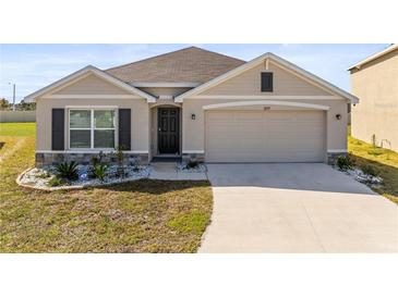 Charming single-story house featuring a two-car garage, manicured lawn, and inviting facade at 2839 Gumbo Limbo Dr, Wimauma, FL 33598